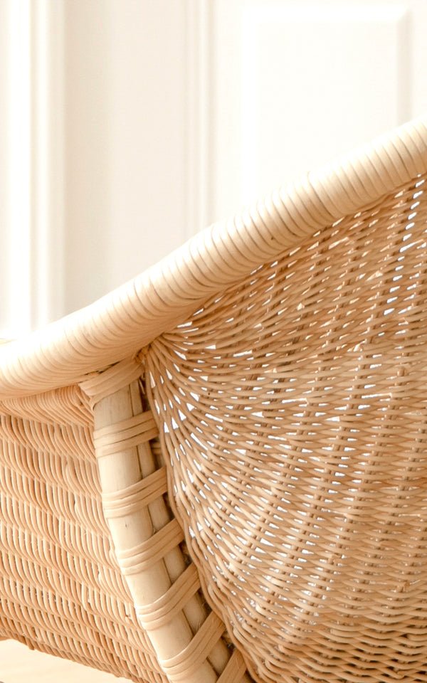 Dette er et nærbillede af Madame Lænestol i natural core weave rattan frame. Fintvævet rattanrygdetalje med blødt lys.