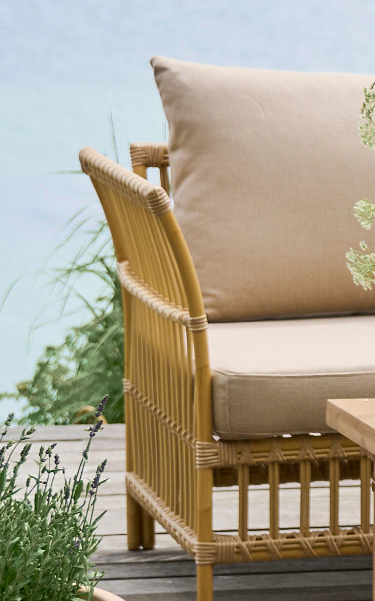 Dette er et nærbillede af Maggie Sofa Hjørnemodul i natural aluminium artfibre. Vertikal latramme med omviklede samlinger og beige pude.