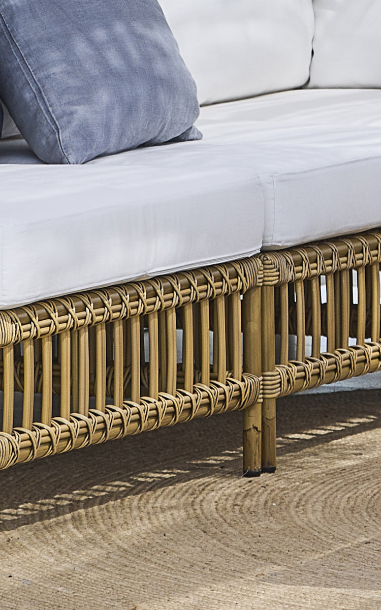 Dette er et nærbillede af Maggie Sofa Centermodul i antique aluminium artfibre. Bundrammens krydsfletningsmønster og jutetæppe nedenunder.