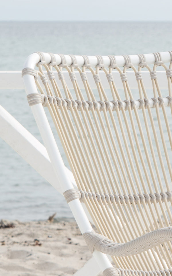 Dette er et nærbillede af Monet Exterior Rocking Chair i dove white aluminium artfibre. Detalje af sløjfebue-ryggen.