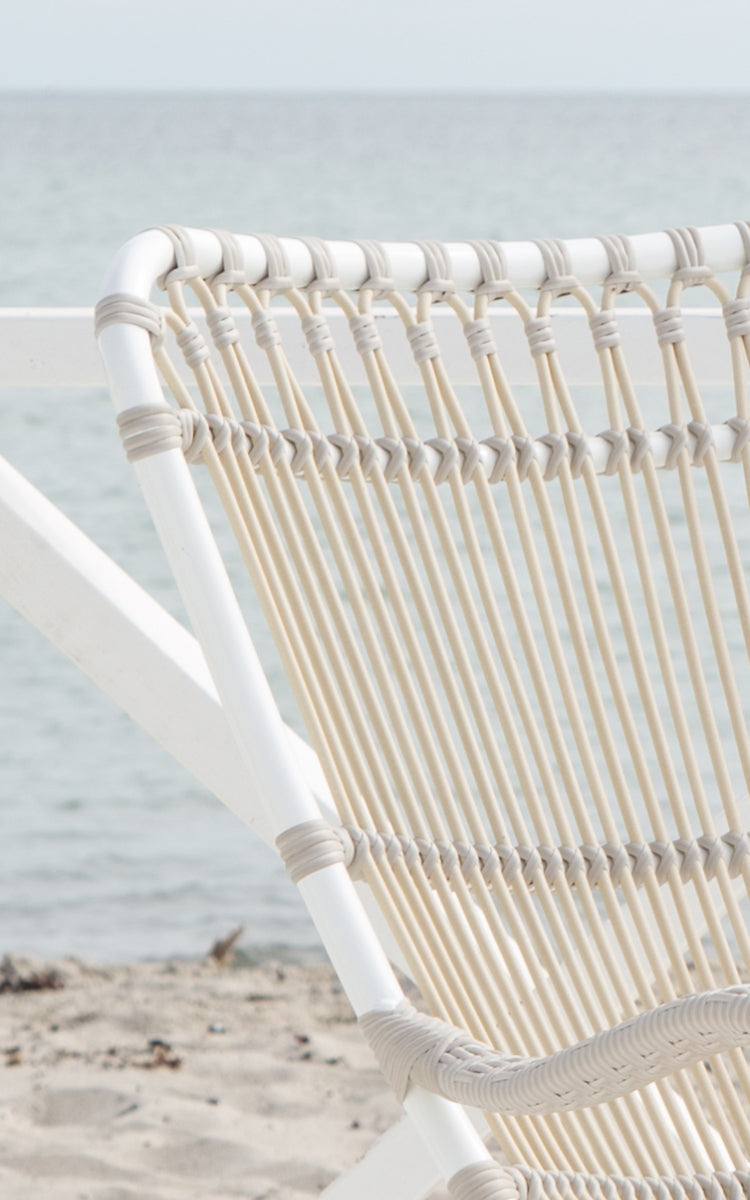 Dette er et nærbillede af Monet Exterior Rocking Chair i dove white aluminium artfibre. Detalje af sløjfebue-ryggen.