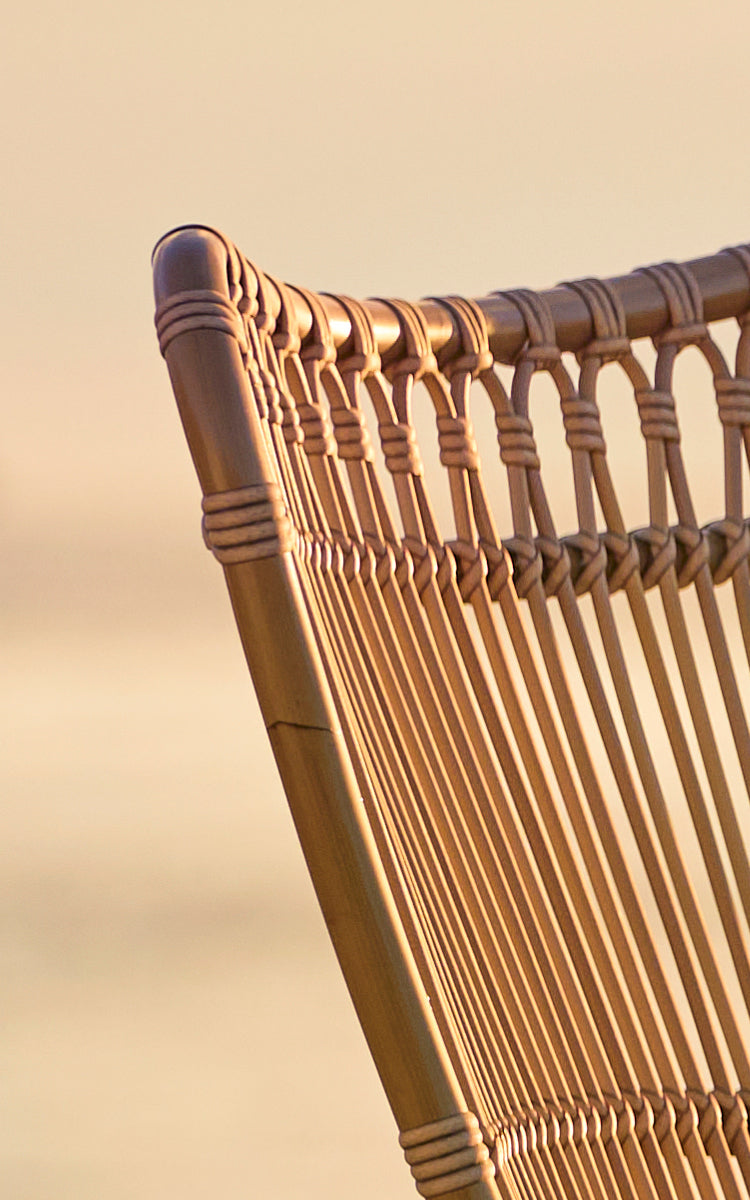 Dette er et nærbillede af Monet Exterior Lounge Chair i antique aluminium artfibre. Detalje af sløjfebuerne og de vertikale stænger.