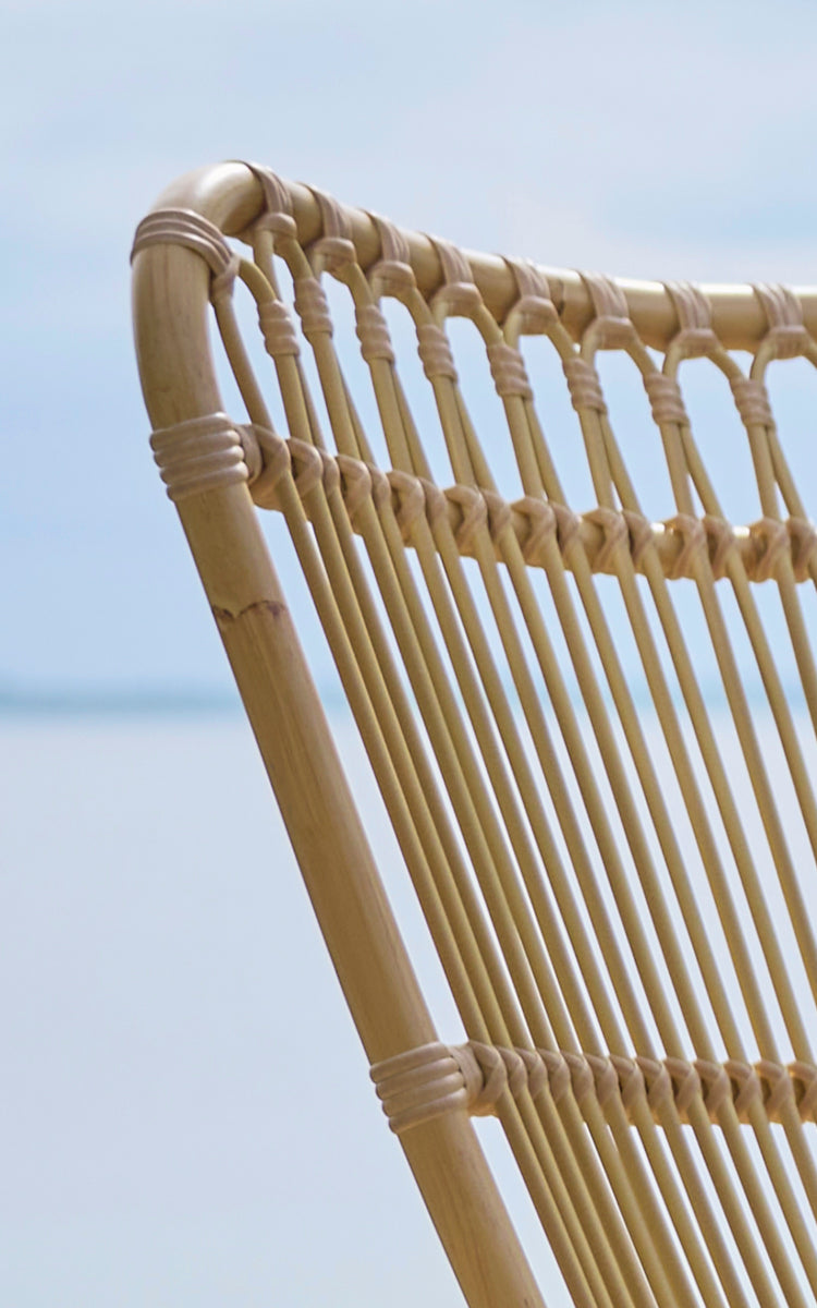 Dette er et nærbillede af Monet Exterior Lounge Chair i natural aluminium artfibre. Detalje af sløjfebuerne og stangsædet.
