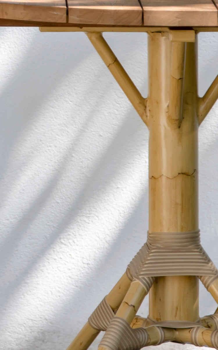Dette er et nærbillede af Nicole Cáfe Table | Teak Ø80 cm i natural aluminium artfibre. Detalje af den flettede tekstur og stelkonstruktion.