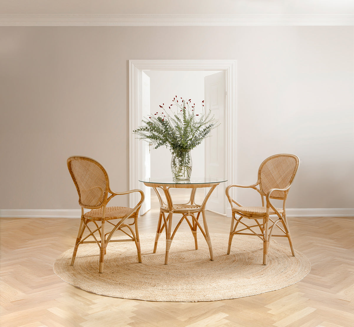 Dette er et livsstilsbillede af Rossini Dining Armchair i natural rattan. Stylet i et lyst interiør.