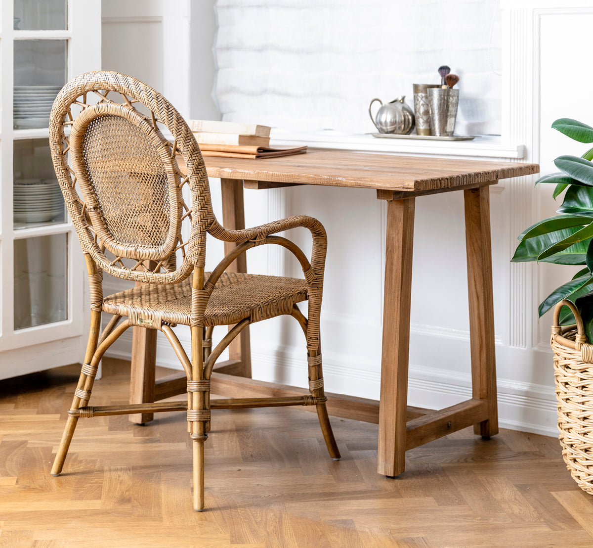 Dette er et livsstilsbillede af Romantica Spisebordsstol i antique rattan. Arrangeret i en grå stennichenindretning med smedejernsvæglamper.