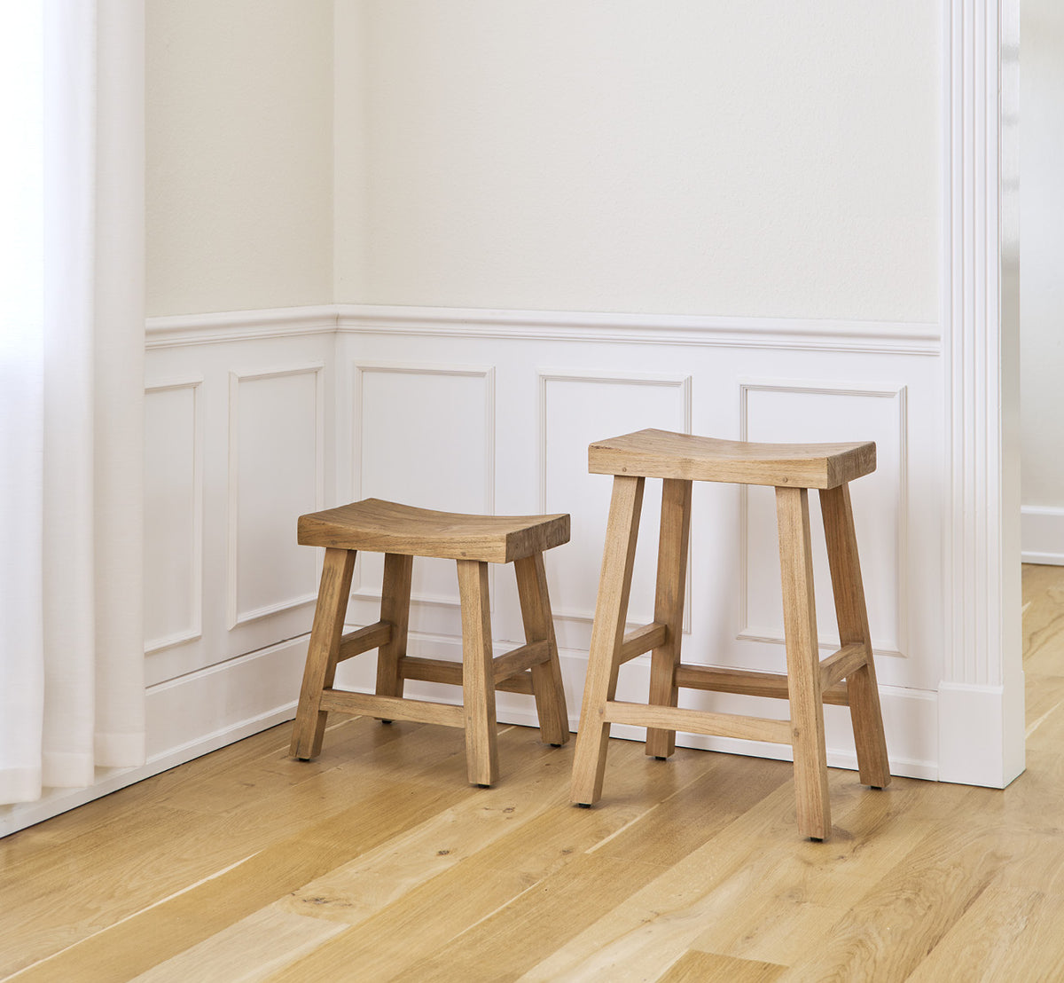 Dette er et livsstilsbillede af Charles Skammel i teak indoor, i et lyst hvidt interiør med lambrisering og sildebensgulv.