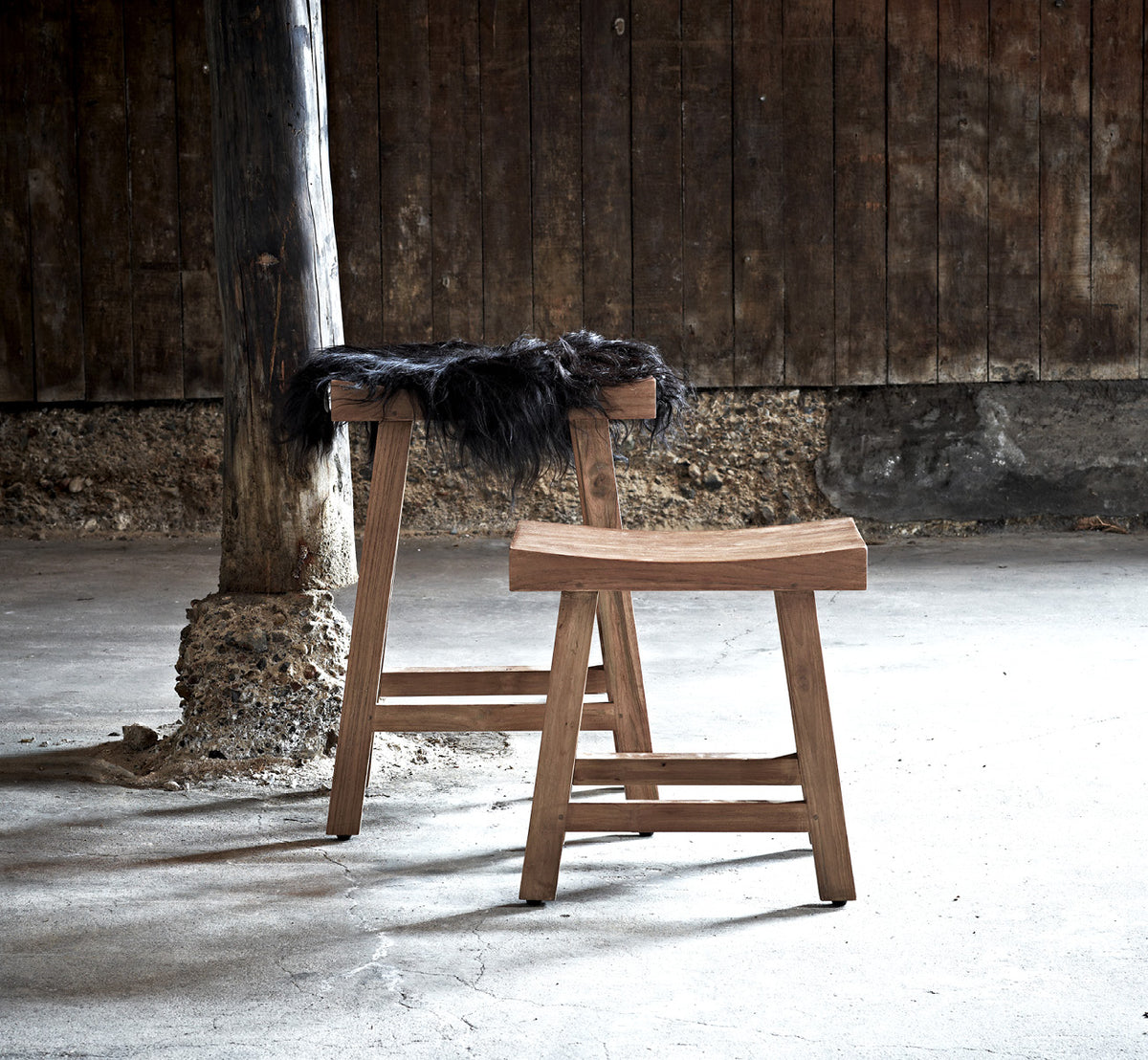 Dette er et livsstilsbillede af Charles Skammel i teak indoor, i et lyst hvidt interiør med lambrisering og sildebensgulv.