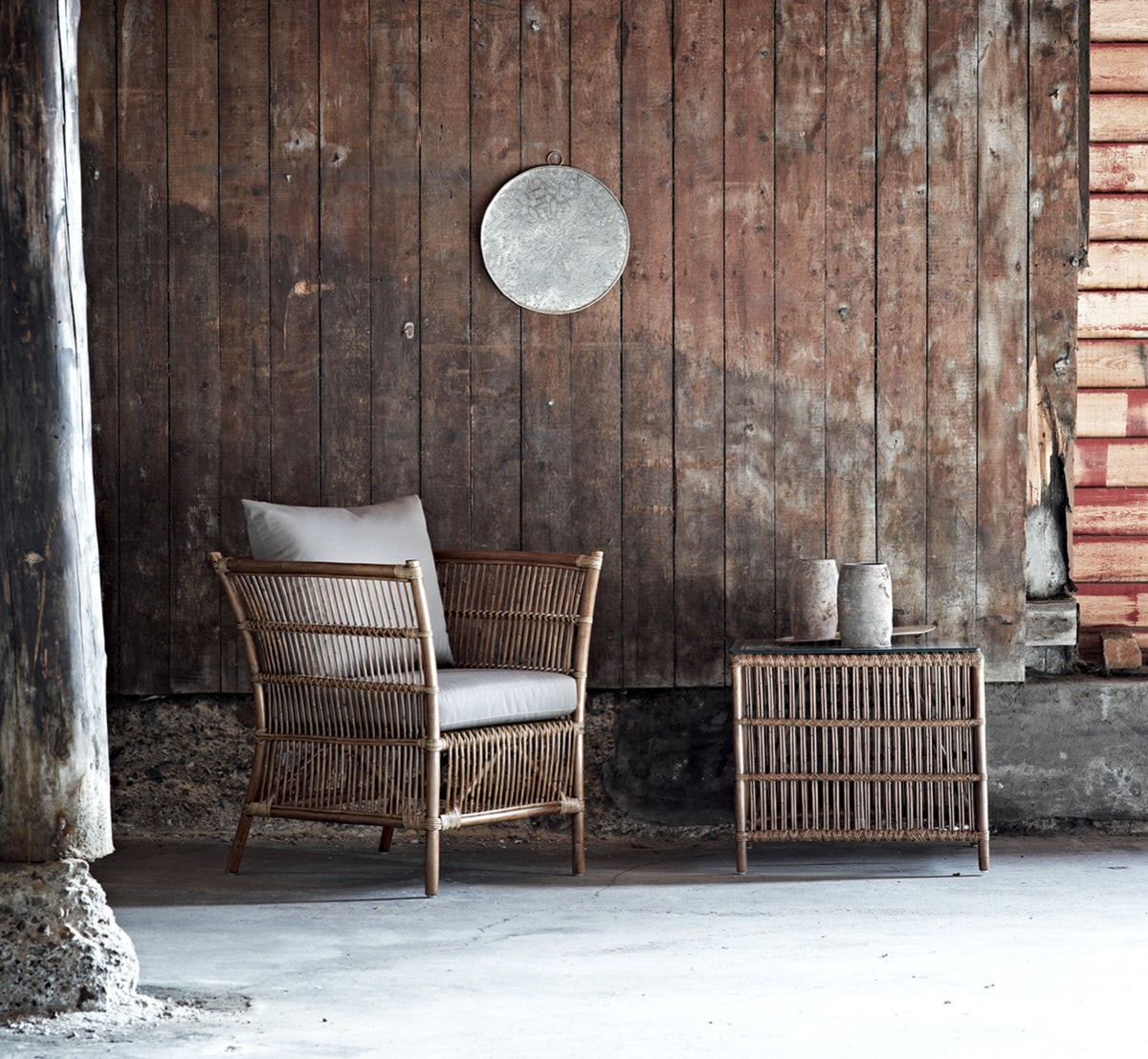 Dette er et livsstilsbillede af Donatello Sidebord i antique rattan, i et lyst interiør med hvide panelvægge og sildebensgulv.