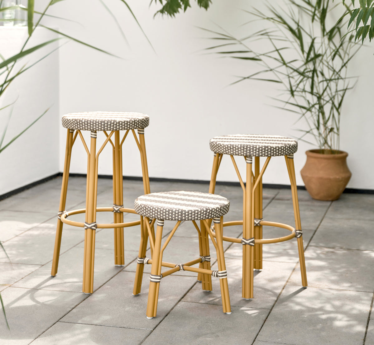 Dette er et livsstilsbillede af Simone Udendørs skammel i almond aluminium frame striped cappuccino ivory artfibre. Stylet i et lyst interiør.
