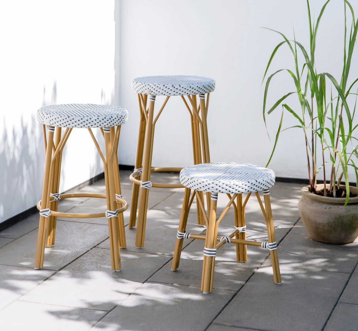 Dette er et livsstilsbillede af Simone Udendørs skammel i almond aluminium frame white w cappuccino dot artfibre.