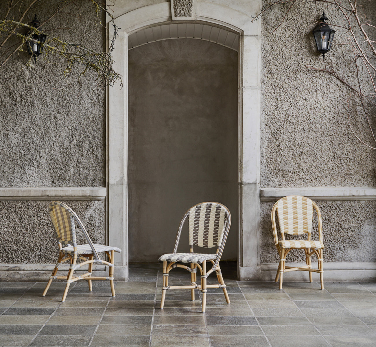 Dette er et livsstilsbillede af Sofie Spisebordsstol i striped cappuccino ivory artfibre skin on rattan frame. Stylet i et lyst interiør.