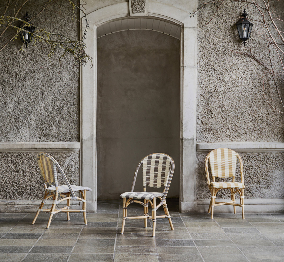 Dette er et livsstilsbillede af Sofie Spisebordsstol i striped grey ivory artfibre skin on rattan frame. Stylet i et lyst interiør.