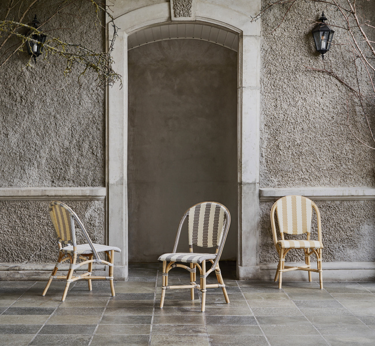 Dette er et livsstilsbillede af Sofie Spisebordsstol i striped honey ivory artfibre skin on rattan frame. Stylet i et lyst interiør.