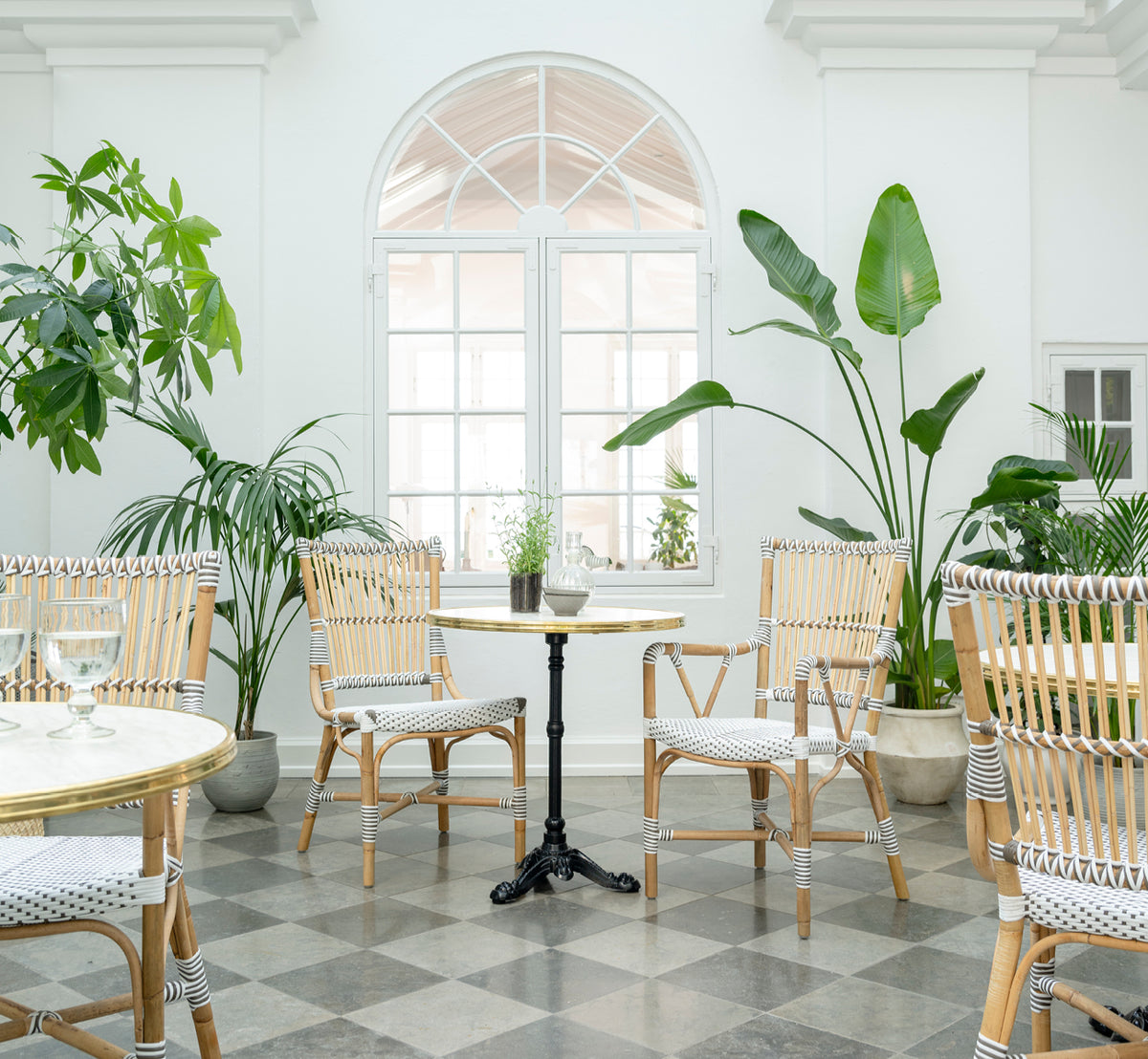 Dette er et livsstilsbillede af Monique Spisebordsstol i white w cappuccino dot artfibre skin on rattan frame. Stylet i et lyst interiør.