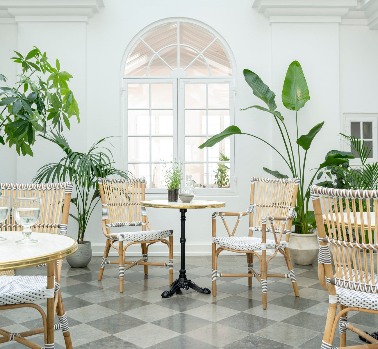 Dette er et livsstilsbillede af Monique Spisebordsstol i white w cappuccino dot artfibre skin on rattan frame. Stylet i et lyst interiør.