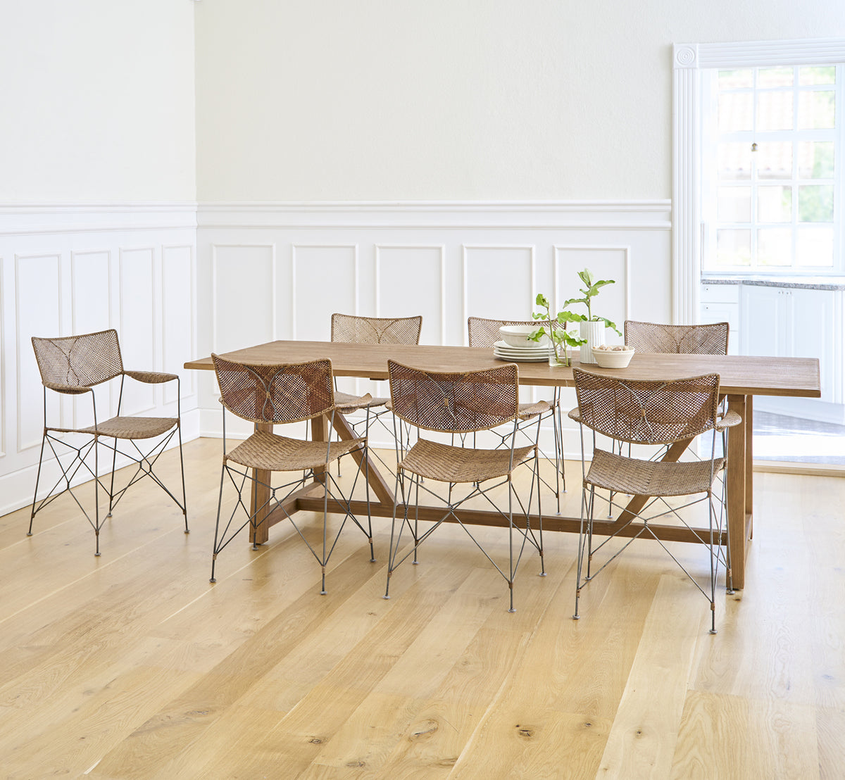 Dette er et livsstilsbillede af Lucas Teak Dining Table 240X100 cm i teak indoor. Kombineret med moderne stole i et lyst rum med hvide panelvægge.