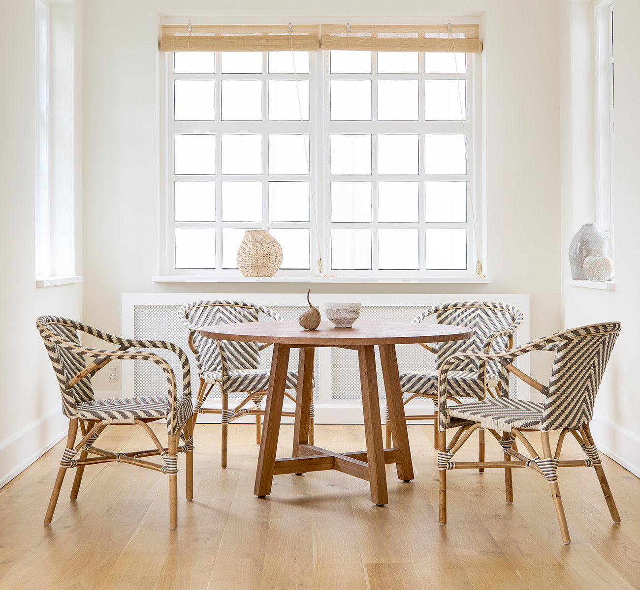 Dette er et livsstilsbillede af Aksel Spisebord i teak indoor, i et lyst spiseområde med store vinduer og lyst trægulv.