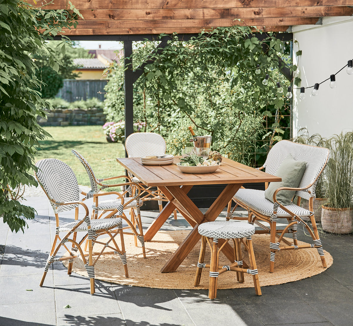 Dette er et livsstilsbillede af Colonial Bord 160 i outdoor Teak, på en strandterrasse med hvidt trædæk og havudsigt.