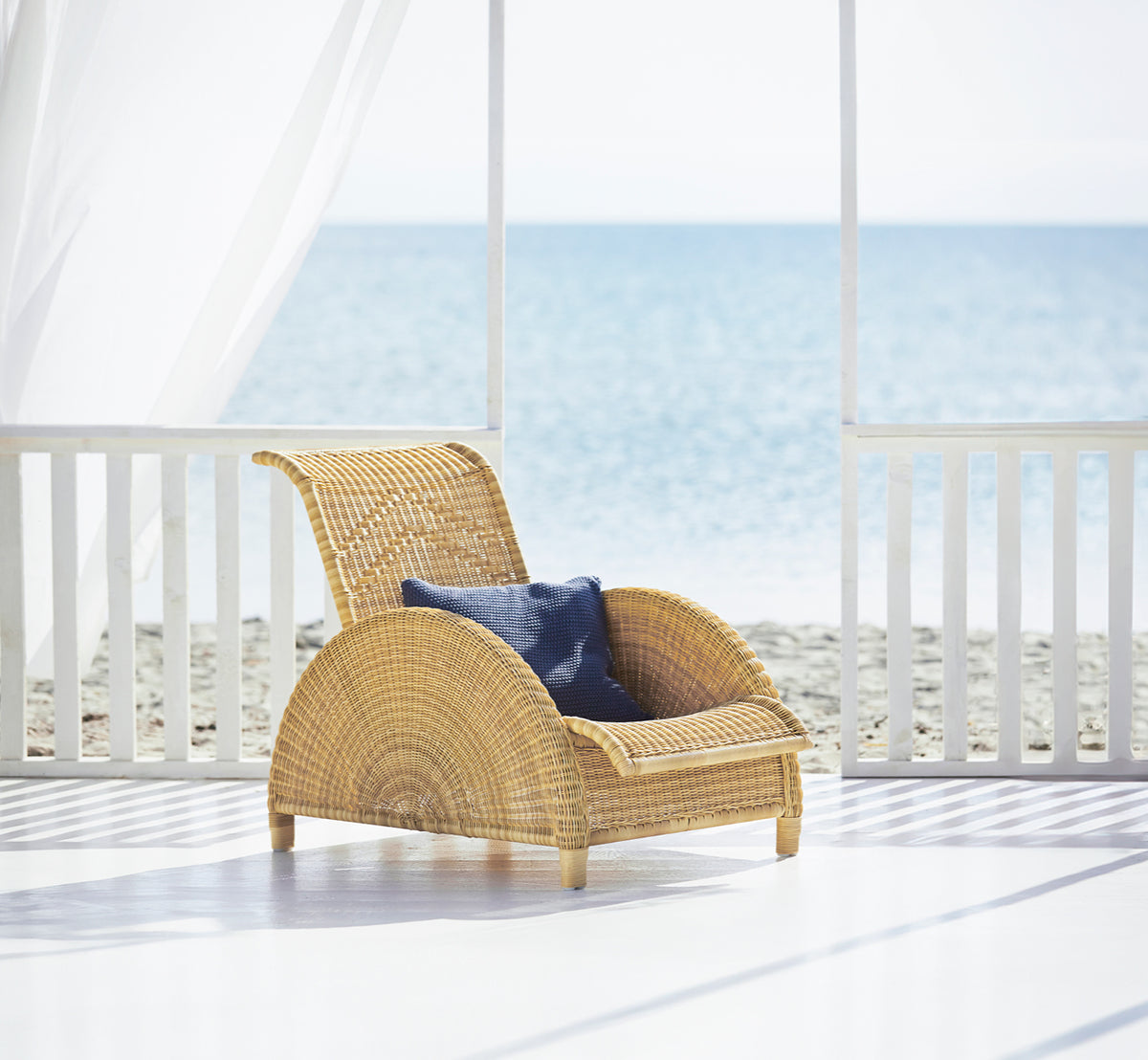 Dette er et livsstilsbillede af Paris Udendørs lænestol i natural core weave artfibre aluminium. Stylet i et lyst interiør.