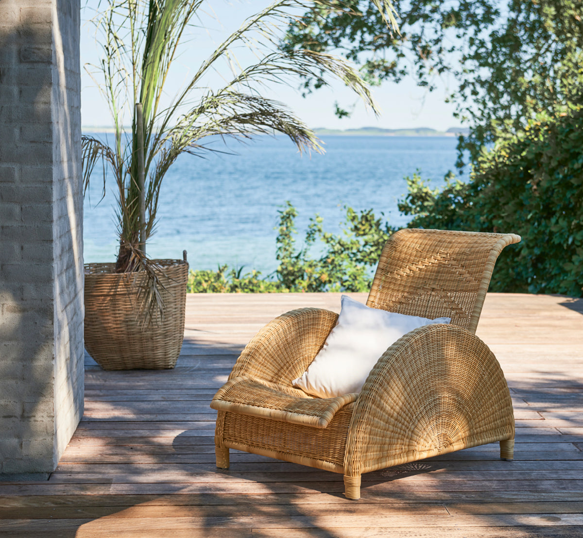 Dette er et livsstilsbillede af Paris Udendørs lænestol i natural core weave artfibre aluminium. Stylet i et lyst interiør.