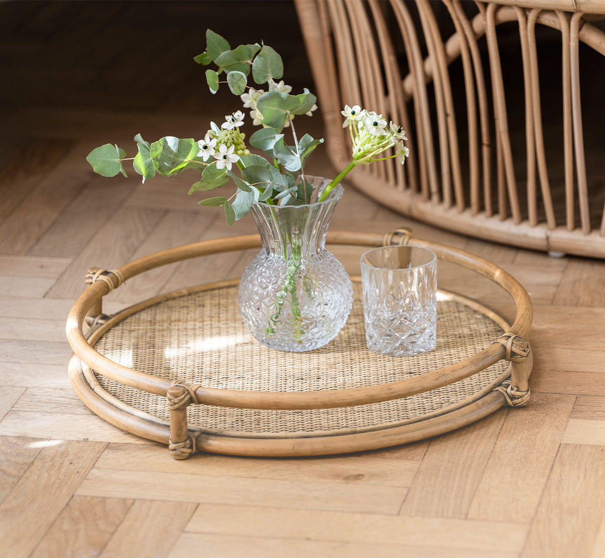 Dette er et livsstilsbillede af Andreas Bakke i natural Rattan, i et lyst interiør med sildebensgulv.