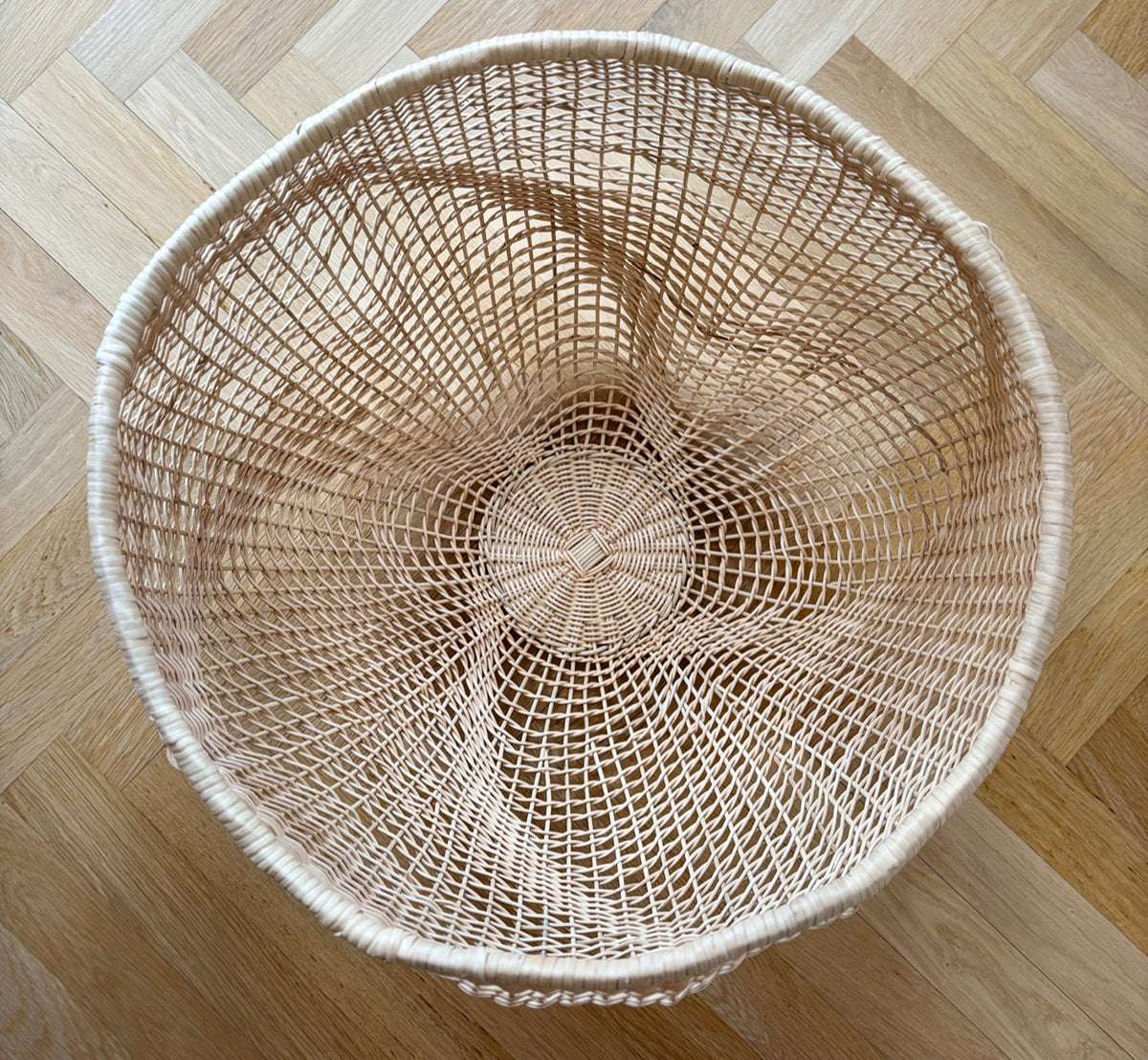 Dette er et livsstilsbillede af Folia Kurv i natural core weave iron frame, i et lyst hvidt interiør med lambrisering, stylet med tørrede blomster.