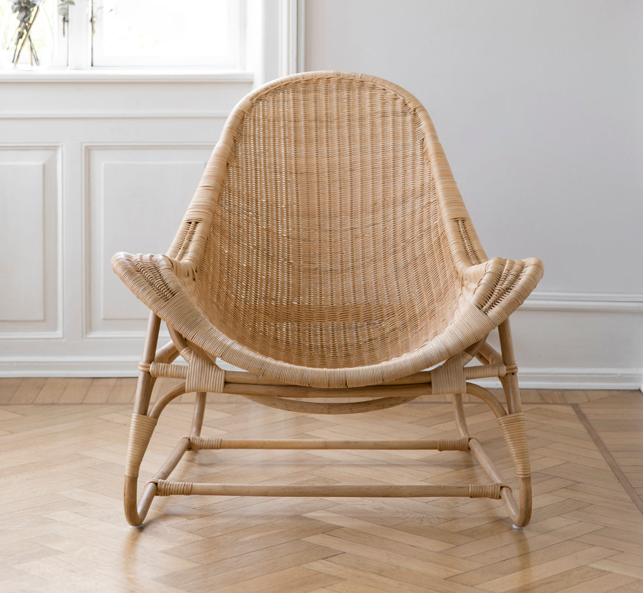 Dette er et livsstilsbillede af Pacifique Lænestol i natural core weave rattan frame. Stylet i et lyst interiør.