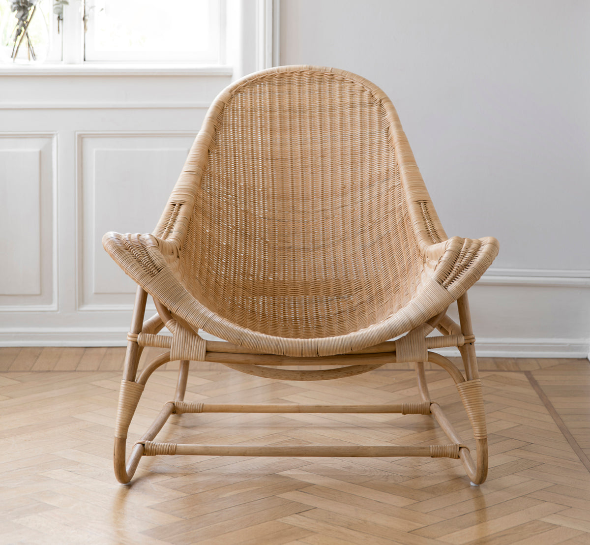 Dette er et livsstilsbillede af Pacifique Lænestol i natural core weave rattan frame. Stylet i et lyst interiør.
