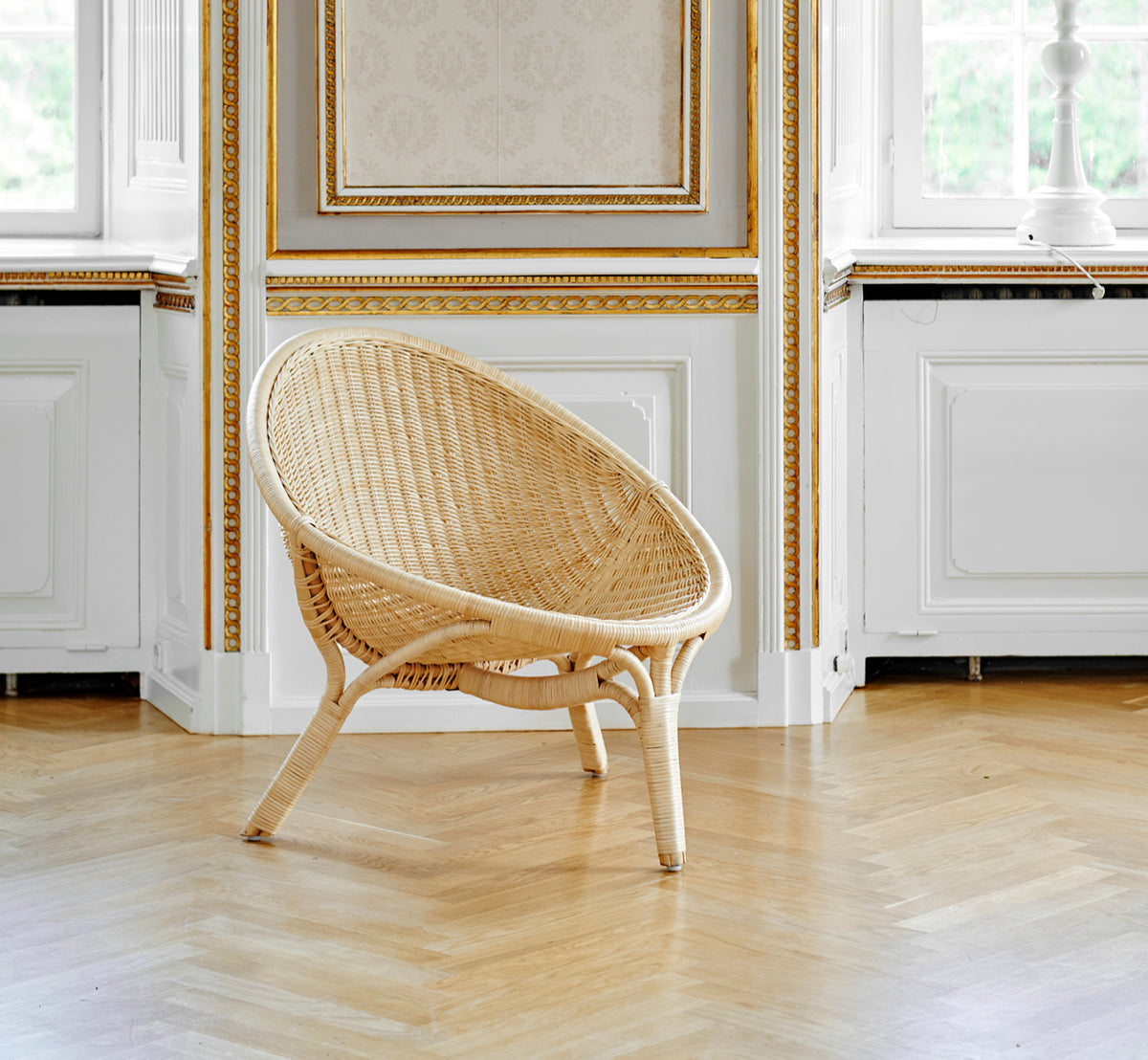 Dette er et livsstilsbillede af Rana Lænestol i natural core weave rattan frame. Stylet i et lyst interiør.