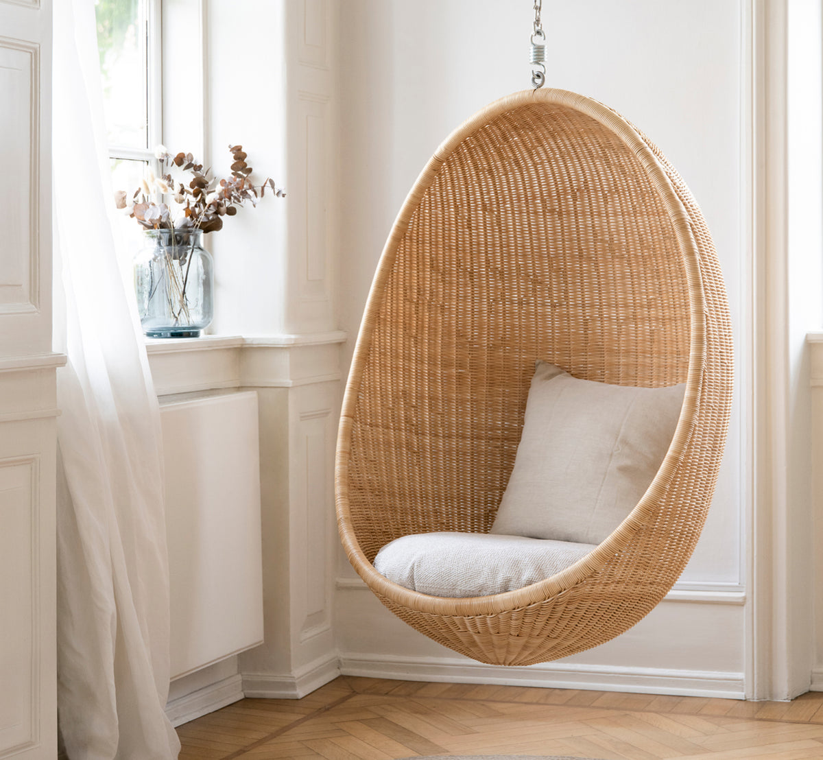 Dette er et livsstilsbillede af Hanging Hængeæg-stol i natural core weave Rattan frame, i et elegant klassisk interiør med forseggjorte forgyldte.