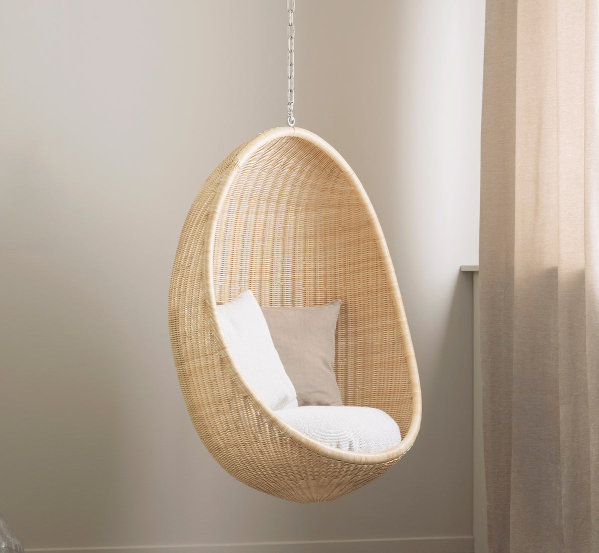 Dette er et livsstilsbillede af Hanging Hængeæg-stol i natural core weave Rattan frame, i et elegant klassisk interiør med forseggjorte forgyldte.