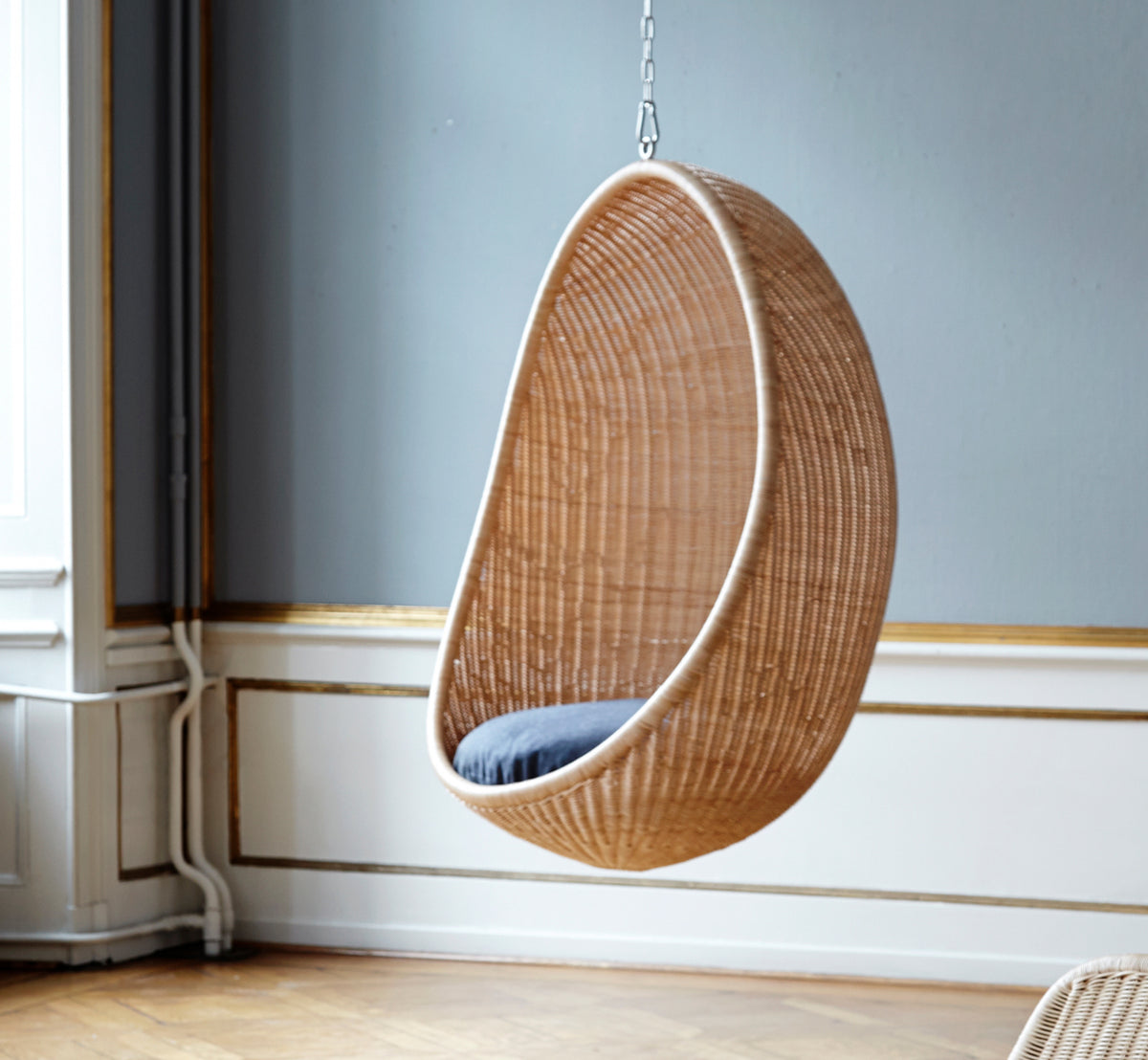Dette er et livsstilsbillede af Hanging Hængeæg-stol i natural core weave Rattan frame, i et elegant klassisk interiør med forseggjorte forgyldte.