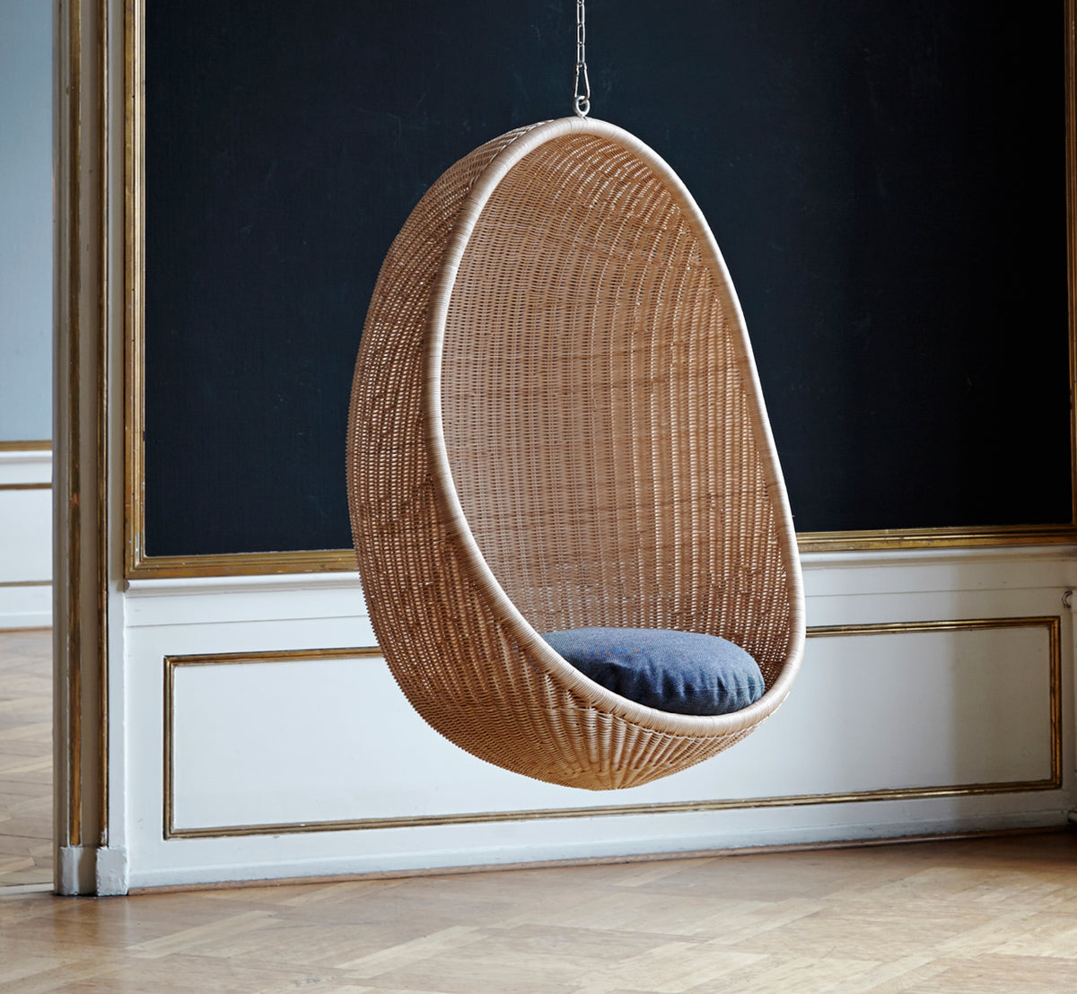 Dette er et livsstilsbillede af Hanging Hængeæg-stol i natural core weave Rattan frame, i et elegant klassisk interiør med forseggjorte forgyldte.