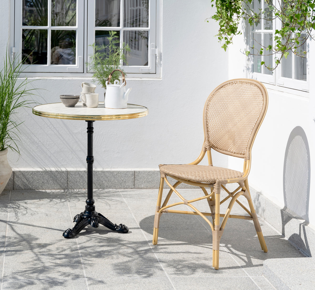 Dette er et livsstilsbillede af Rossini Udendørs spisebordsstol i natural aluminium artfibre. Stylet i et lyst interiør.