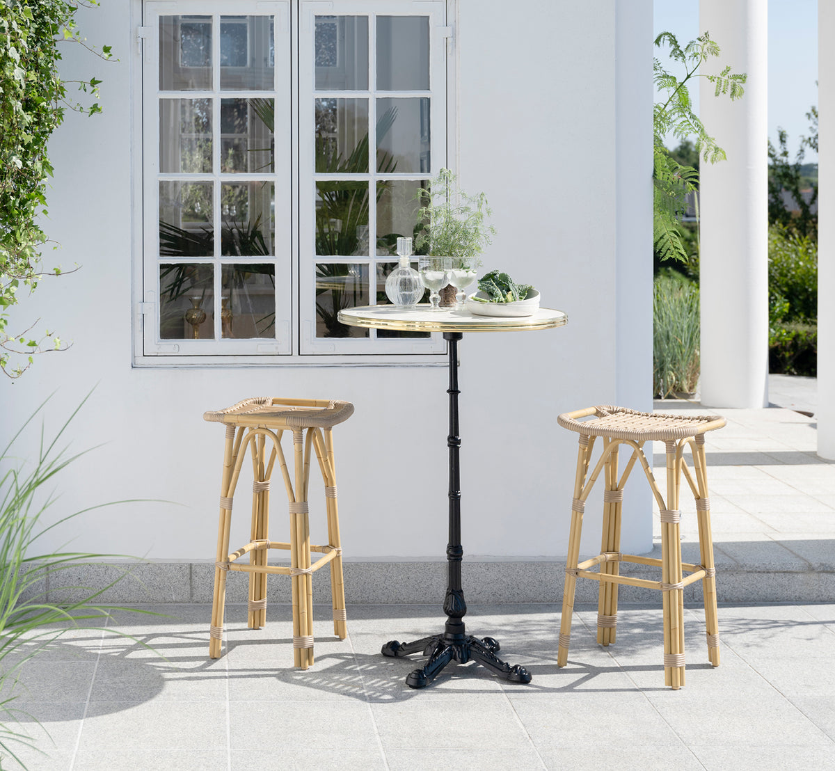 Dette er et livsstilsbillede af Salsa Udendørs barstol i natural aluminium artfibre. Elegant terrasse med barbord og grønne planter.