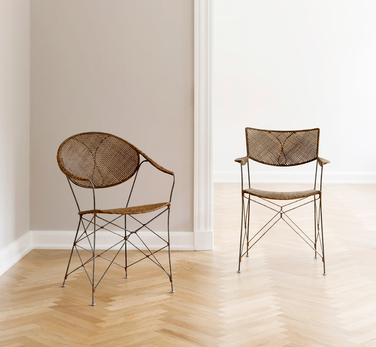 Dette er et livsstilsbillede af Funky Spisebordsstol i hazelnut rattan iron frame, i et lyst interiør med hvide panelvægge og sildebensgulv.