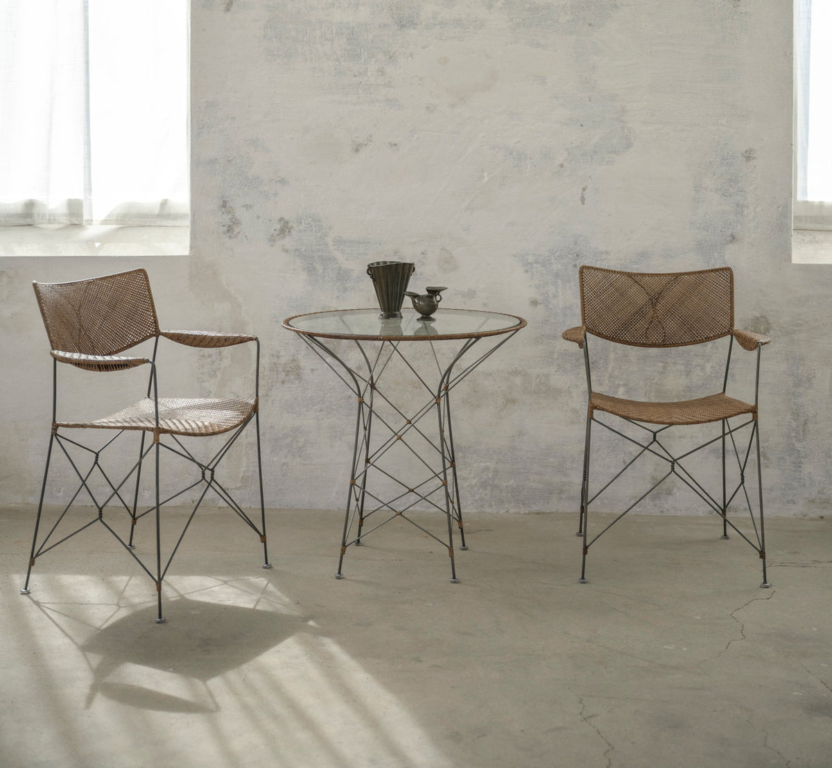 Dette er et livsstilsbillede af Funky Cafébord i hazelnut rattan iron frame. Med stole i et lyst, solbeskinnet rum.