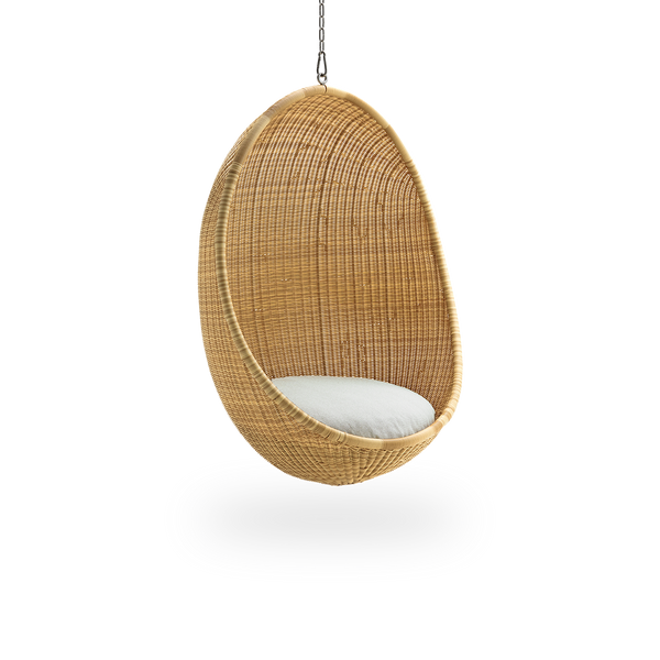 Side view af Hanging Egg udendørs i farven Natural. Hængestolen har en rund form og er fuldt flettet i ArtFibre på en aluminiumsramme.